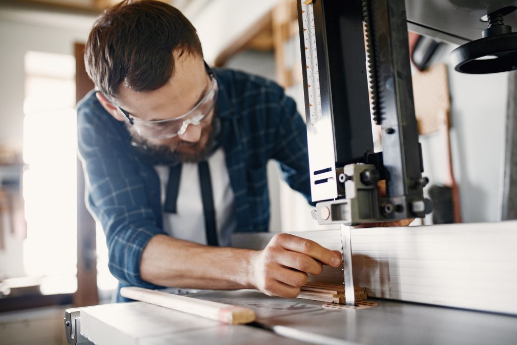 Professional carpenter working with sawing machine